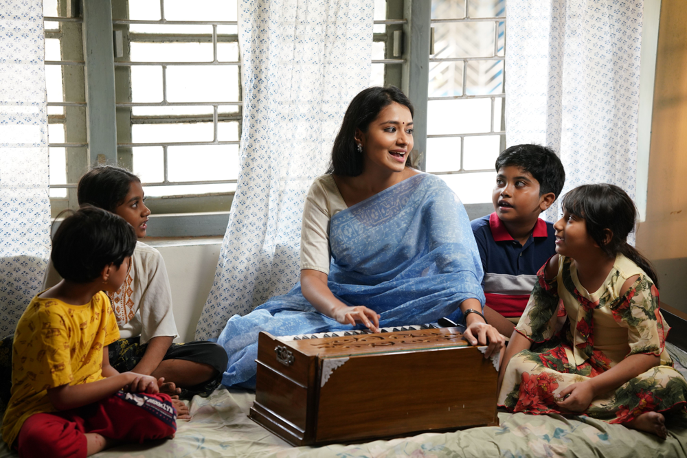 Indian children learning music together with a harmonium in a classroom setting